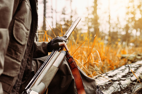 Autumn hunting season. Woman hunter with a gun. 