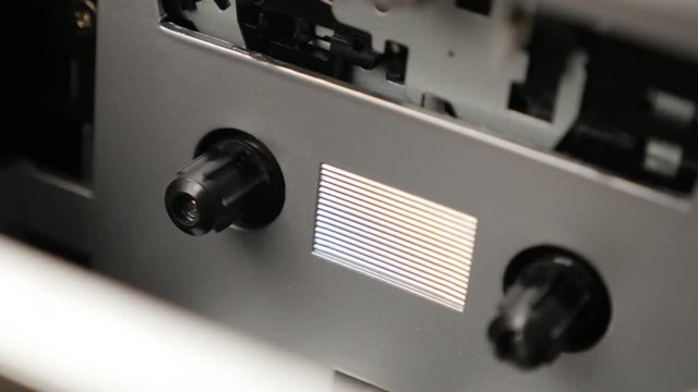 Supply spindle rotates on music tape playing mechanism 3840X2160 UltraHD panning footage - Shallow DOF compact cassette recording device slow pan 2160p UHD video 
