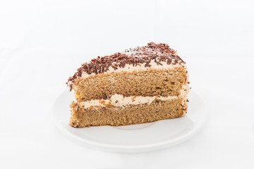 Chocolate cake slice with curl on white dish