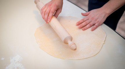 Mother and Daughter Hands Kneading Dough on the table.