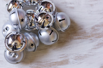 Christmas decoration with jingle bells on white wooden table.