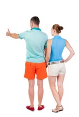 young couple pointing at wal Back view