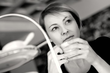Junge blonde Frau beim Frühstück in einer Bar, trinkt Café