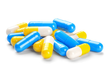 pile of medical pills blue and yellow color on  white background