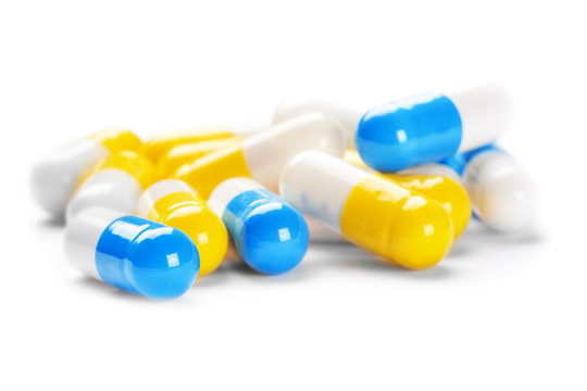 pile of medical pills yellow color on white background