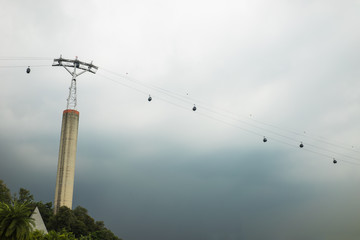 Obraz premium Cable way to Sentosa island, Singapre against black heavy clouds before raining