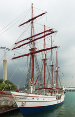 Obraz premium Tourist sailing boat on river against black clouds