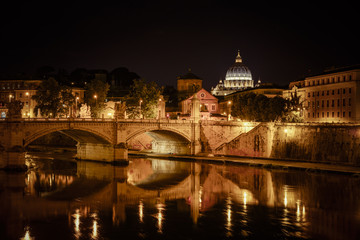 Fototapeta na wymiar Basilica of San Pietro at night overlooking the Tevere river and surrounding historical landmarks of Rome.