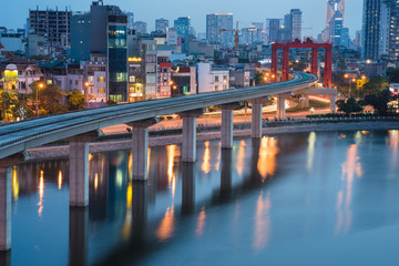 Naklejka premium Aerial view of Hanoi cityscape by twilight period, with Dong Da lake and under construction Cat Linh - Ha Dong elevated railway
