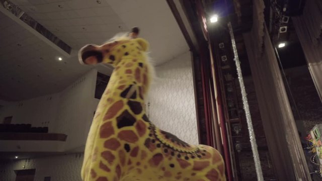 Toy Giraffe stands swinging on the theatrical stage