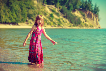 Toddler girl wearing dress playing in water