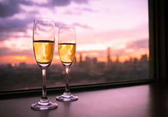 Pair of champaign glasses over looking a city view. 