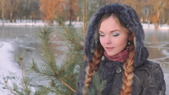 Young beautiful woman posing over winter forest. Outdoor winter portrait over snowy background. slow motion from 50 fps Full HD