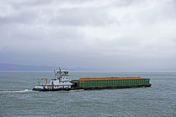 pusher tug and barge going up the Columbia river in Astoria Oregon