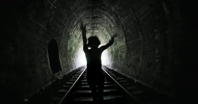 Evil female silhouette chasing and running in scary dark tunnel nightmare video