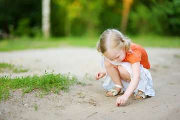 Adorable little girl catching little babyfrogs