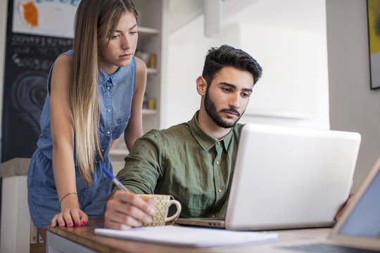 Young Couple Using Laptop At Home