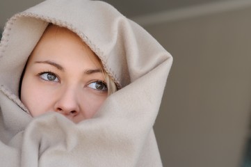 Porträt einer in eine Fleecedecke gehüllten jungen Frau