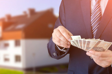 Polish businessman holds money. The loan on the house