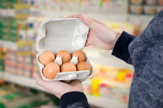 Man holding egg box in supermarket