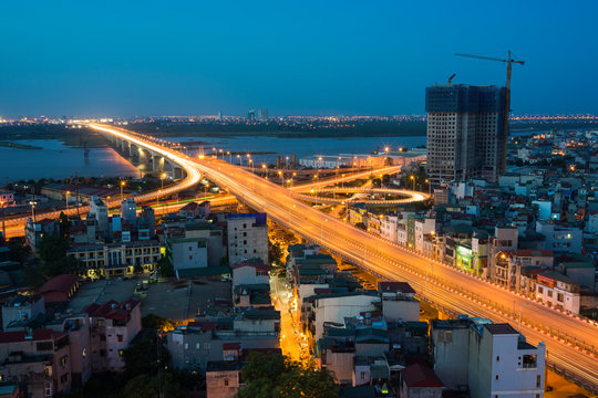 Aerial view of Hanoi cityscape at twilight. Vinh Tuy bridge crossing Red River.