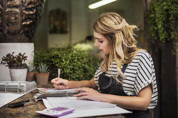 Florist calculating in flower shop