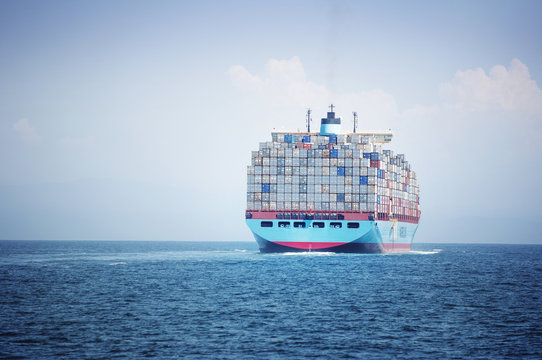 Container ship loaded with cargo containers sailing on sea against sky