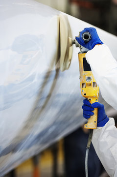 Cropped image of worker using sander on airplane wing at industry