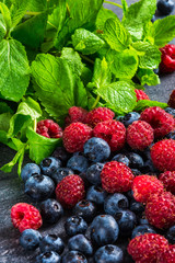 strawberries blackberries blueberries and mint arranged on the table