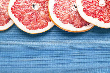 grapefruit slices on blue wooden table background