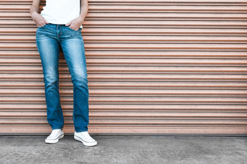 Female posing in blue jeans and sneakers. 
