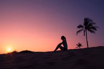 Fototapeta na wymiar Girl watching the sunset on the beach. 
