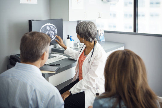 Female doctor explaining report to couple in clinic
