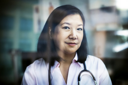 Portrait of confident female doctor seen through window