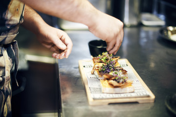 Cropped image of chef garnishing food at kitchen counter