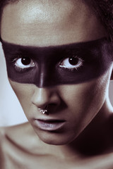Beauty fashion shot of young man with nose rings and black strip line makeup and white eyelash. Male beauty portrait. studio shot.
