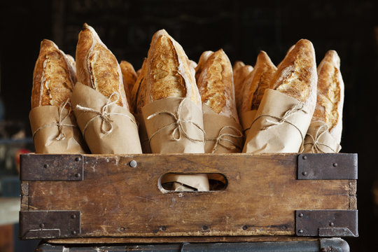 Bread loaves in wooden container at bakery