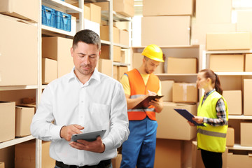 Young businessman with tablet at warehouse