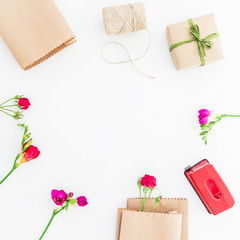 Frame with flowers and gift box isolated on white background. Flat lay, Top view.