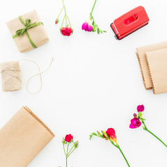 Frame with red flowers, gift box and details isolated on white background. Flat lay, Top view.