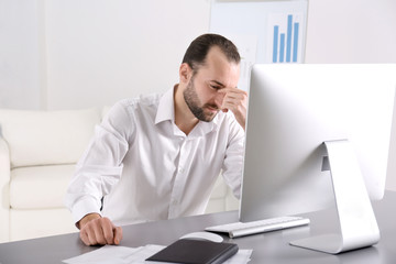 Fototapeta premium Depressed handsome man sitting in office