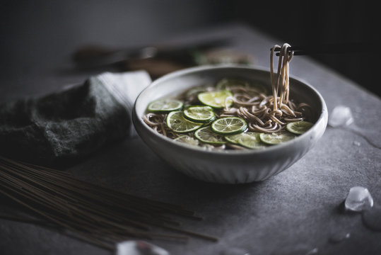 Close up of soba noodles in bowl with chopsticks on kitchen counter