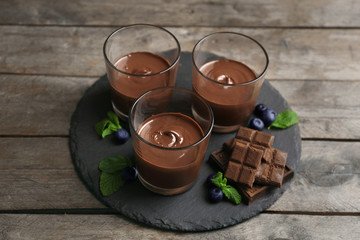 Chocolate mousse in glasses on wooden background