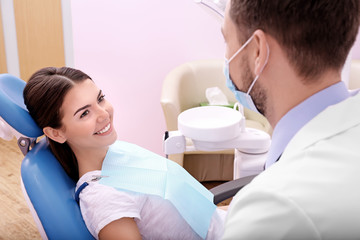 Fototapeta premium Young woman visiting dentist in clinic