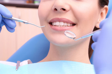 Dentist examining patient's teeth in clinic, closeup