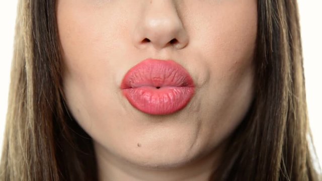 Close-up of sensuous woman mouth blowing a very long kiss