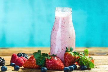 Fruit yoghurt in a bottle on the summer background.