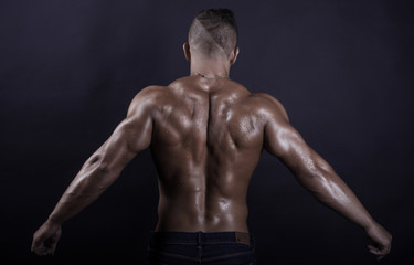 Handsome, muscular and sexy back of young man stretching arms