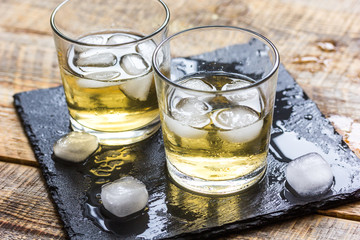 glass of whiskey on wooden background