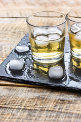 glass of whiskey on wooden background